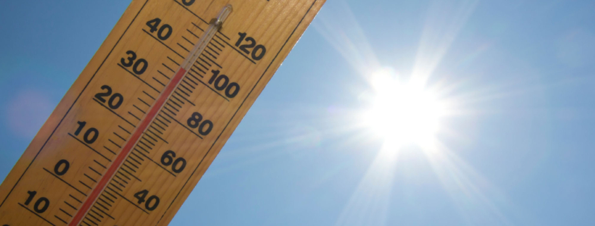 Praca w upale - termometr z ukazaną wysoką temperaturą, w tle ostre słońce