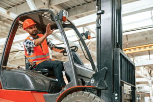Mężczyzna na wózku widłowym machający do współpracowników