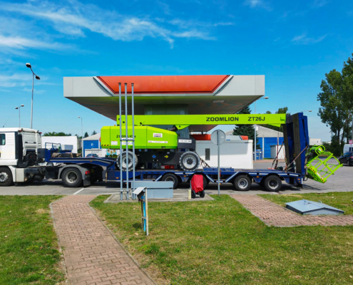 Duży zielony podnośnik podczas transportu