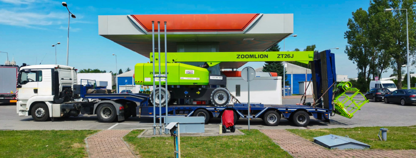 Duży zielony podnośnik podczas transportu